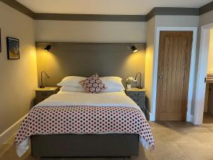 a bedroom with a large bed and two night stands at Award Winning Lodge at Ewen Barn, Ewen, Cirencester in Cirencester +24 photos