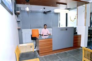 a man standing at a counter in an office at hotel cloud 20 in Jambusar