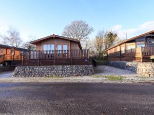 a house with a fence and a stone wall at Kingfisher Lodge - Arnside 14 in Carnforth