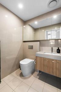 ein Badezimmer mit Toilette und Waschbecken in der Unterkunft Upper North Shore Haven - A Tranquil Treetop Escape in Warrawee + 15 Fotos