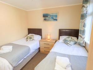 a bedroom with two beds and a lamp on a night stand at Kingfisher Lodge - Arnside 14 in Carnforth