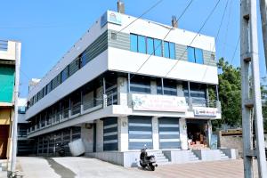 a man on a motorcycle parked in front of a building at hotel cloud 20 in Jambusar