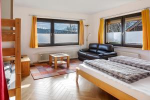 Haus Wintersonne في Falkau: غرفة نوم بها سرير وكرسي ومكتب +99 صورة