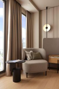 a living room with a chair and a table at ATLANTIC Hotel Frankfurt in Frankfurt