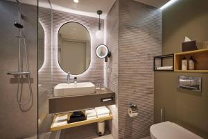 a bathroom with a sink and a mirror at ATLANTIC Hotel Frankfurt in Frankfurt
