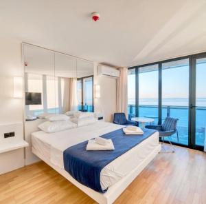 Un dormitorio con una cama grande con vista al mar. en ORBI CITY grand first line sea view, en Batumi