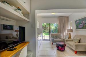 a living room with a flat screen tv and a living room at Stay Wilderness in Wilderness