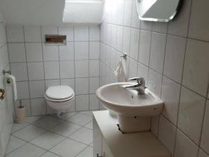 Fewo Am Wald في Balve: حمام أبيض مع حوض ومرحاض +53 صورة