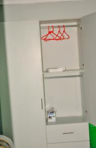 Un refrigerador blanco con perchas rojas en una habitación. en The Verdant suites, en Kakamega