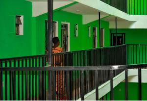 Un edificio verde con una persona delante de él. en The Verdant suites, en Kakamega