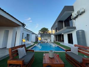 a backyard with two wooden benches and a house at Casa-Pel Tiny House in Palatswe
