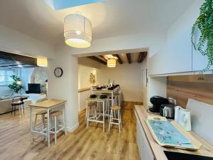 una cucina e un soggiorno con bancone e sgabelli di Casa Bohème Chic ad Angers
