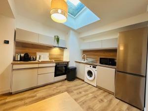 una cucina con frigorifero, lavatrice e asciugatrice di Casa Bohème Chic ad Angers Altre 29 foto