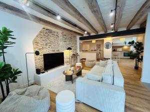 un soggiorno con mobili bianchi e un muro in pietra di Casa Bohème Chic ad Angers
