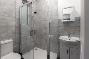 a bathroom with a shower and a toilet and a sink at The Regency | Seafront Lux Apartments! in Southend-on-Sea +31 photos