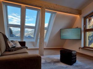a living room with windows and a couch and a tv at Bergschnucke homes in See