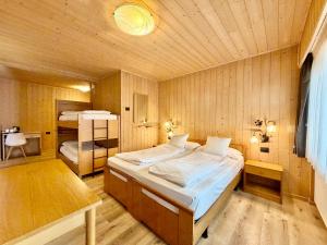 a bedroom with a large bed in a wooden room at B&B Family Accommodation Canazei BIKE FRIENDLY in Canazei