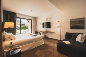 a hotel room with a bed and a couch at Villa Caroline, Lac d'Annecy in Duingt