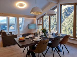 a dining room with a table and chairs with mountains in the background at Bergschnucke homes in See +40 photos