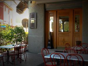 a group of tables and chairs in front of a restaurant at Hotel Bellevue in Pianoro