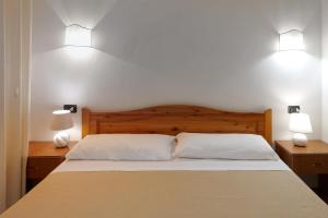 a bed with two white pillows and two lamps at RESIDENCE CERRA in Otranto +21 photos
