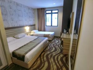 a hotel room with two beds and a window at Victory City Hotel Crystal Bay in Iskandar Puteri +15 photos