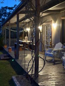 a patio with a table and chairs and lights at The Bloom Farm Cottage  +51 photos