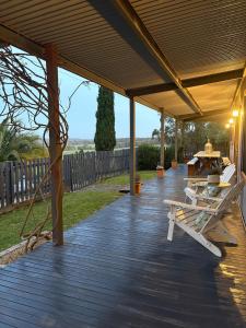 a wooden deck with a table and chairs on it at The Bloom Farm Cottage 