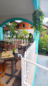 an outdoor patio with tables and chairs and potted plants at Bayside & Beach Inn Langkawi in Pulau Langkawi