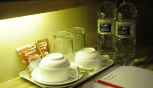 a tray with tea cups and jars on a table at Victory City Hotel Crystal Bay in Iskandar Puteri
