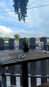 a table with a plant sitting on top of it at Bayside & Beach Inn Langkawi in Pulau Langkawi
