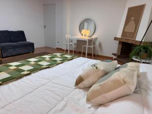 Una cama blanca grande en una habitación con espejo. en Estudio Las Rozas de Madrid, en Las Rozas de Madrid