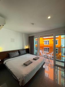 パトンビーチにあるDoze Banglaの大きなベッドとバルコニーのある寝室