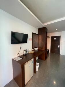 パトンビーチにあるDoze Banglaのデスク、壁掛けテレビが備わる客室です。