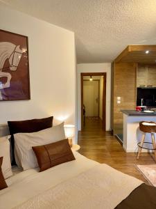 een slaapkamer met een groot bed en een keuken bij LiHam Alpine Suite in Megève