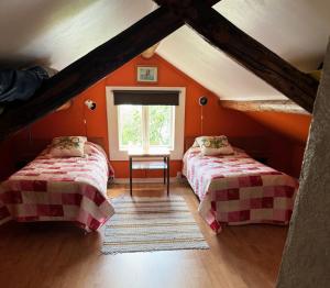 two beds in a attic room with orange walls at Dog-friendly cottage with boat & private jetty at Tjörn SE09170 in Krommeröd