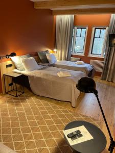 a bedroom with a bed and a desk with a lamp at Park Hotel Brūzis in Smiltene