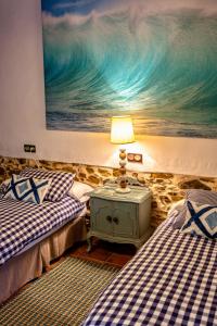 una camera da letto con due letti e un dipinto sul muro di Vivienda rural La Monería a Las Delgadas