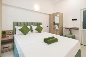 Un dormitorio con una gran cama blanca con almohadas verdes. en Skyport Villa Katunayaka, en Katunayake 44 fotos más