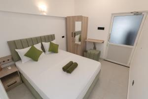 1 dormitorio con cama blanca y almohada verde en Skyport Villa Katunayaka, en Katunayake