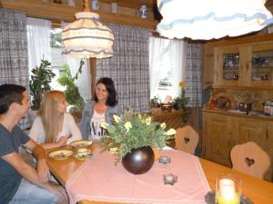 eine Gruppe von Menschen, die um einen Tisch sitzen in der Unterkunft Ferienwohnungen Fontana in Bad Gögging