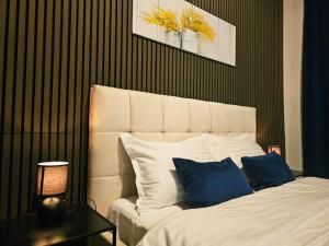 Maison Mimosa avec garage privé في دينانت: غرفة نوم بسرير ابيض مع مخدات زرقاء