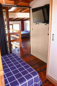 a room with a tv and a room with a bed at Sobrado São Chico, Ubatuba SFS in São Francisco do Sul