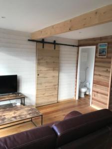 un salon avec un canapé et une télévision dans l'établissement Petite Maison T2, à La Celle-sous-Gouzon