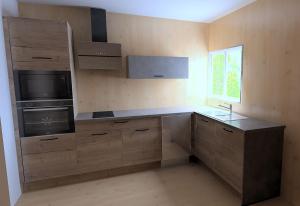 une cuisine avec des armoires en bois et un comptoir dans l'établissement Petite Maison T2, à La Celle-sous-Gouzon