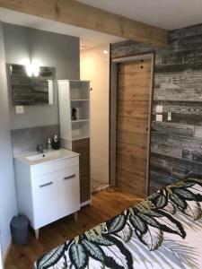 La salle de bains est pourvue d'un lavabo et d'un mur en bois. dans l'établissement Petite Maison T2, à La Celle-sous-Gouzon