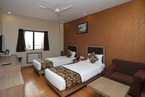 a hotel room with two beds and a couch at Goswami property in Jaipur