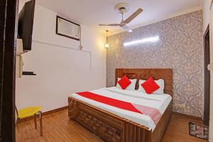 a bedroom with a bed with red pillows at Goswami property in Jaipur