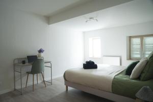 Un dormitorio con una cama y un escritorio y una ventana. en Appartement moderne, 2 chambre, Hyères centre, en Hyères