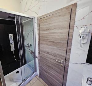 Maison Mimosa avec garage privé في دينانت: دش مع باب خشبي في الحمام